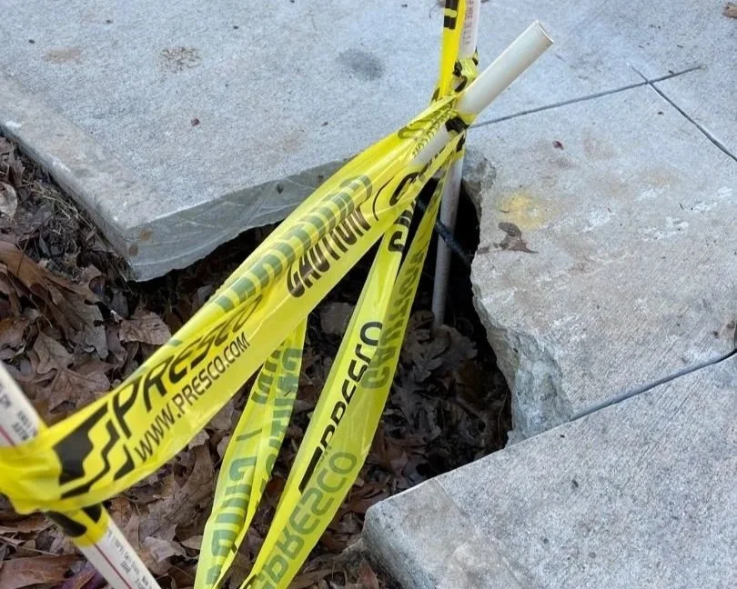 Broken sidewalk where the water main broke that flooded a customer's crawlspace