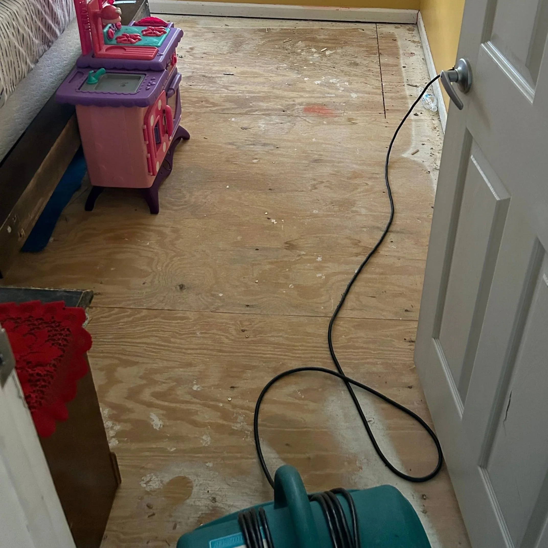 Plywood subfloor after damaged laminate flooring was removed by ServiceMaster