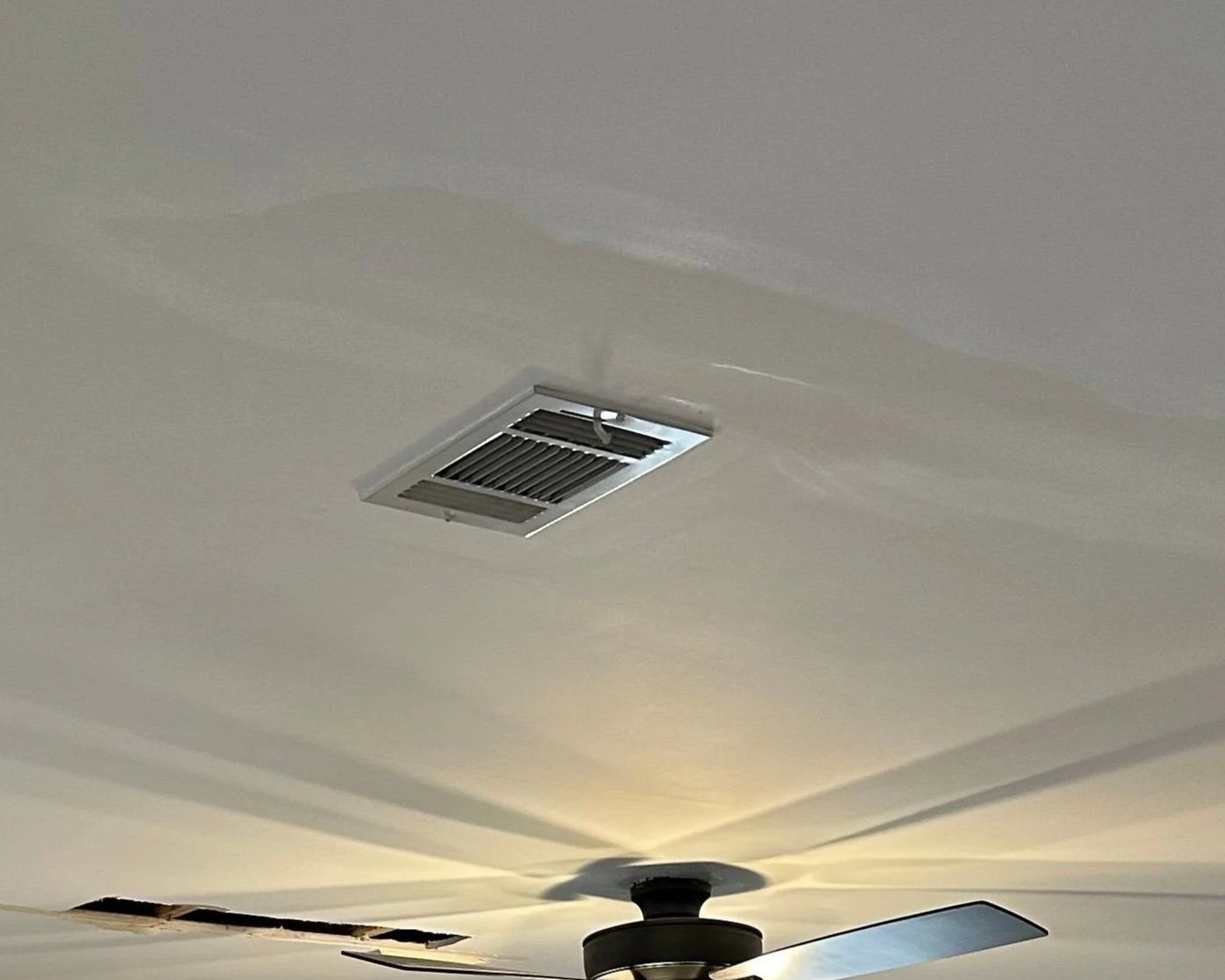 Water damage on living room ceiling from toilet supply line leak in bathroom above