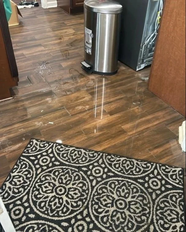 Water on kitchen floor after a pipe burst in the wall