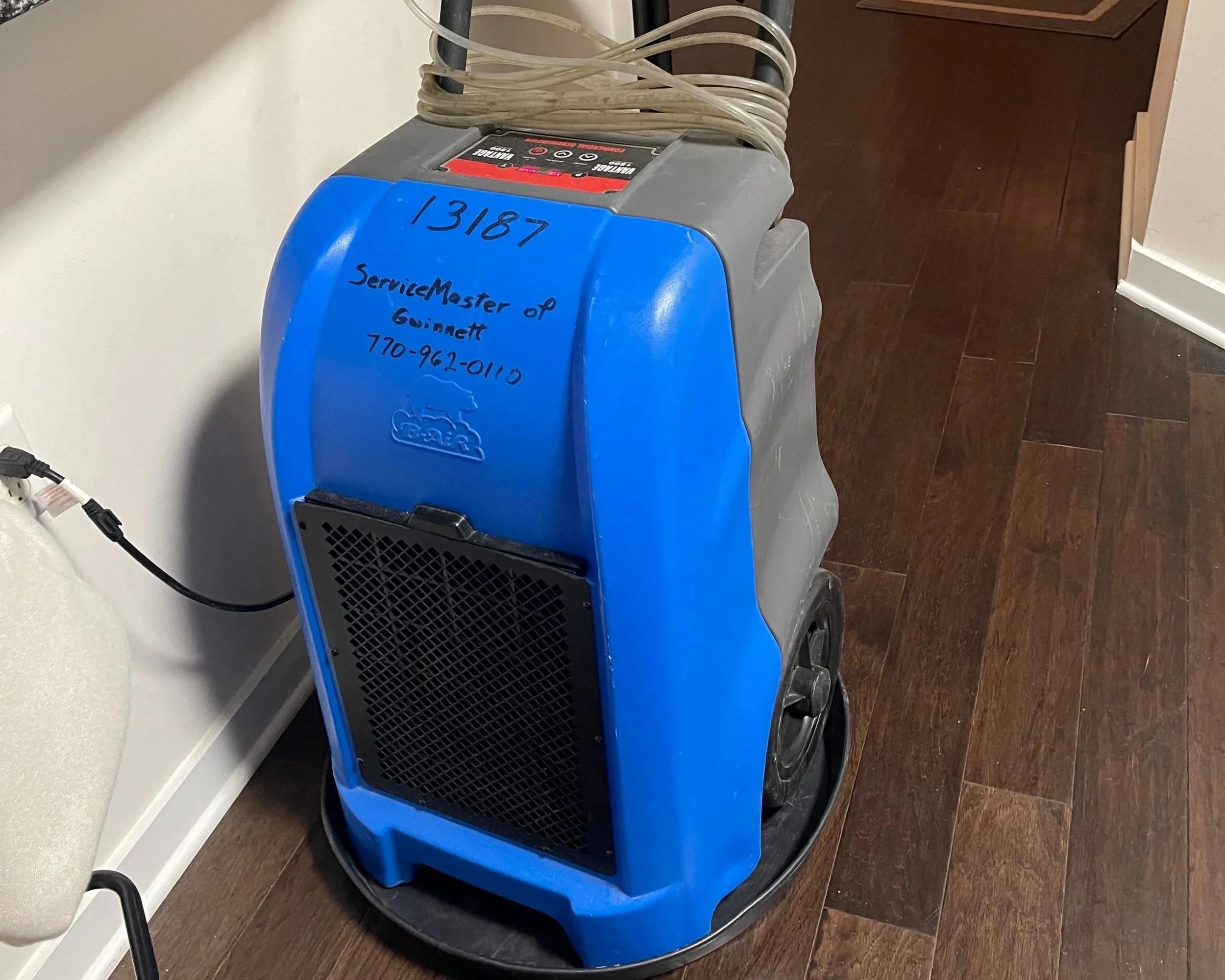 ServiceMaster dehumidifier drying living room area after a dishwasher leak caused water damage