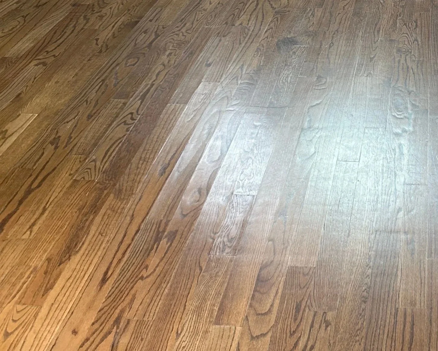 Water damage to hardwood floor in living room after 2nd floor bathtub overflowed