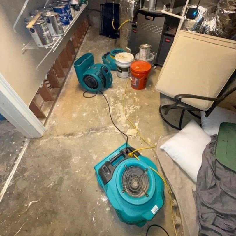 Air movers drying affected workshop wall and floor