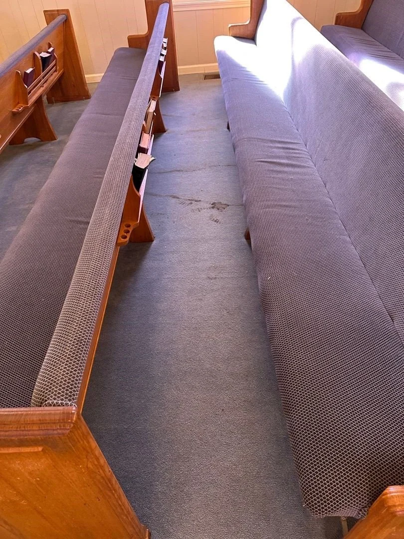 Stained carpet and pews before ServiceMaster carpet and upholstery cleaning