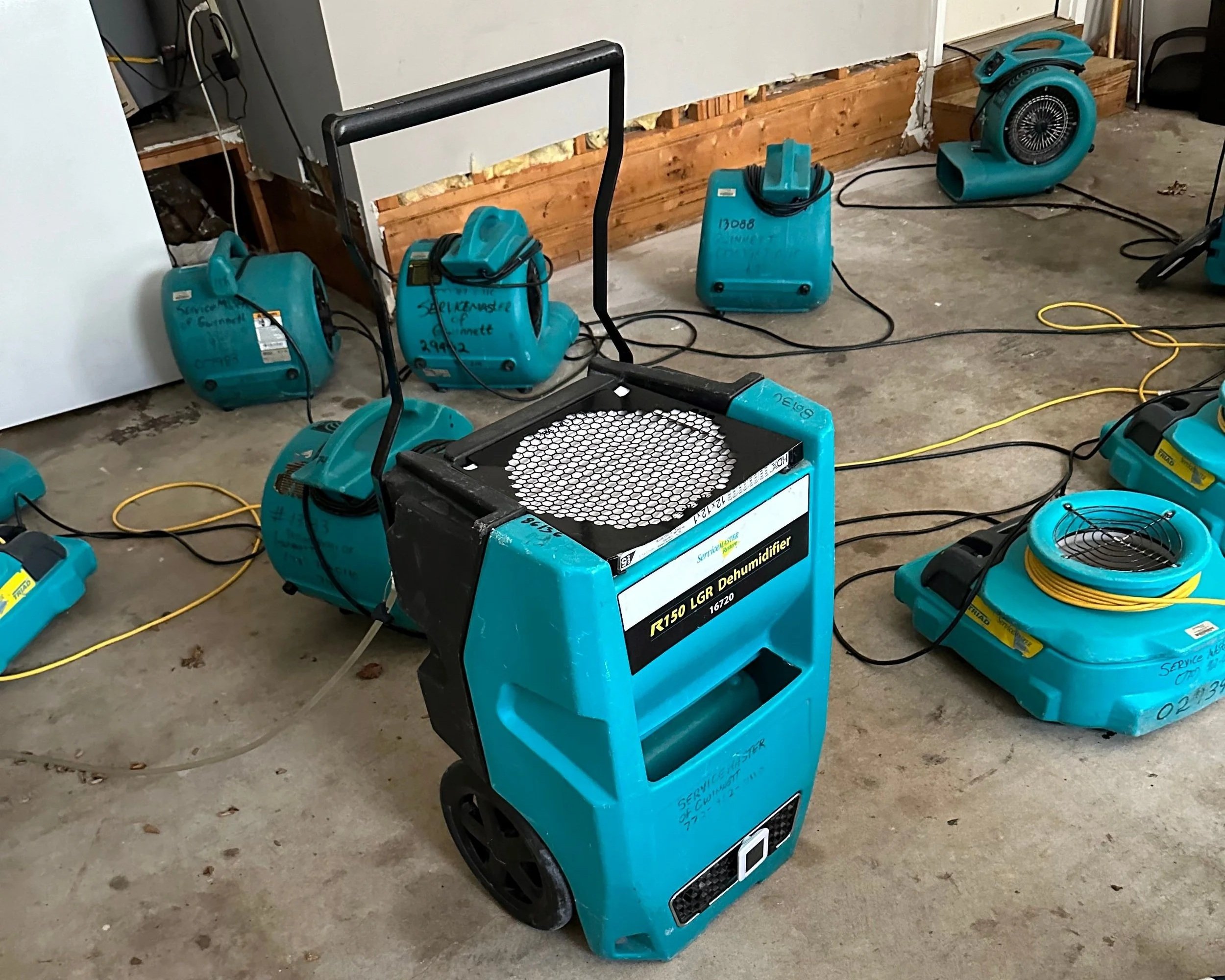 ServiceMaster drying equipment set after damaged drywall was removed to dry garage