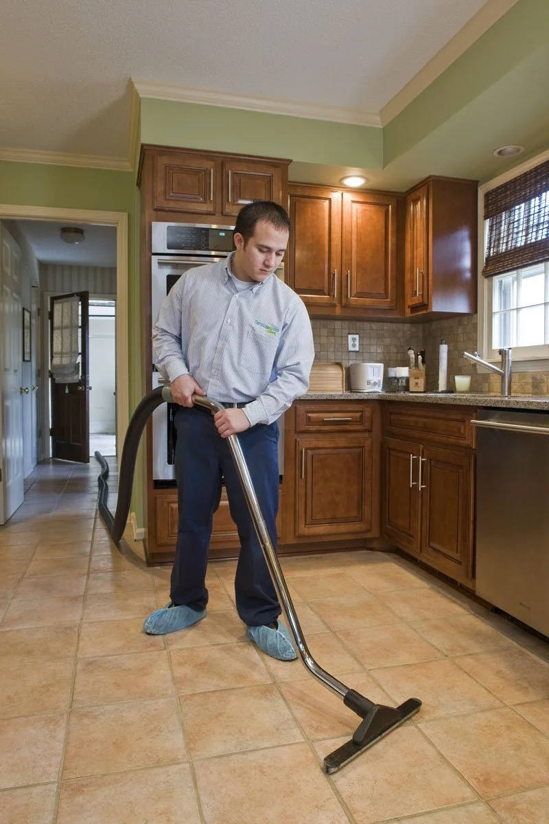 ServiceMaster technician cleaning tile with an extraction wand