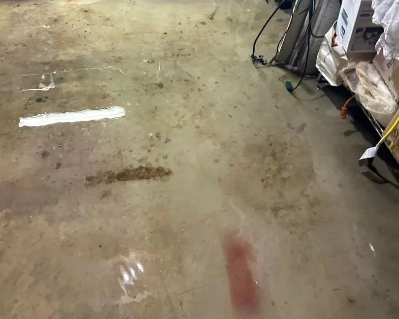 Standing water on concrete in unfinished room after heavy rain flooded the basement