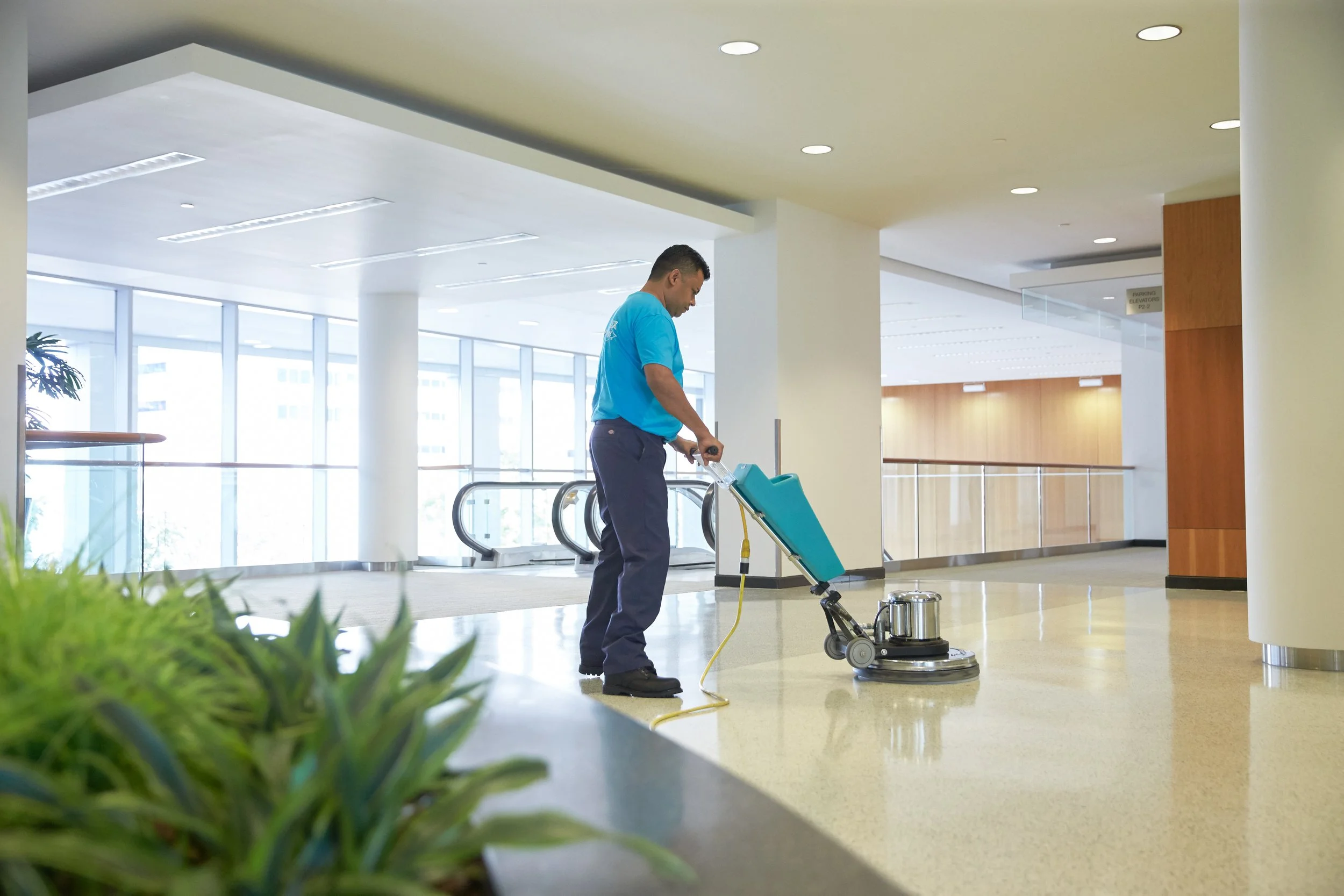 ServiceMaster technician restoring the shine to vinyl flooring in a commercial building