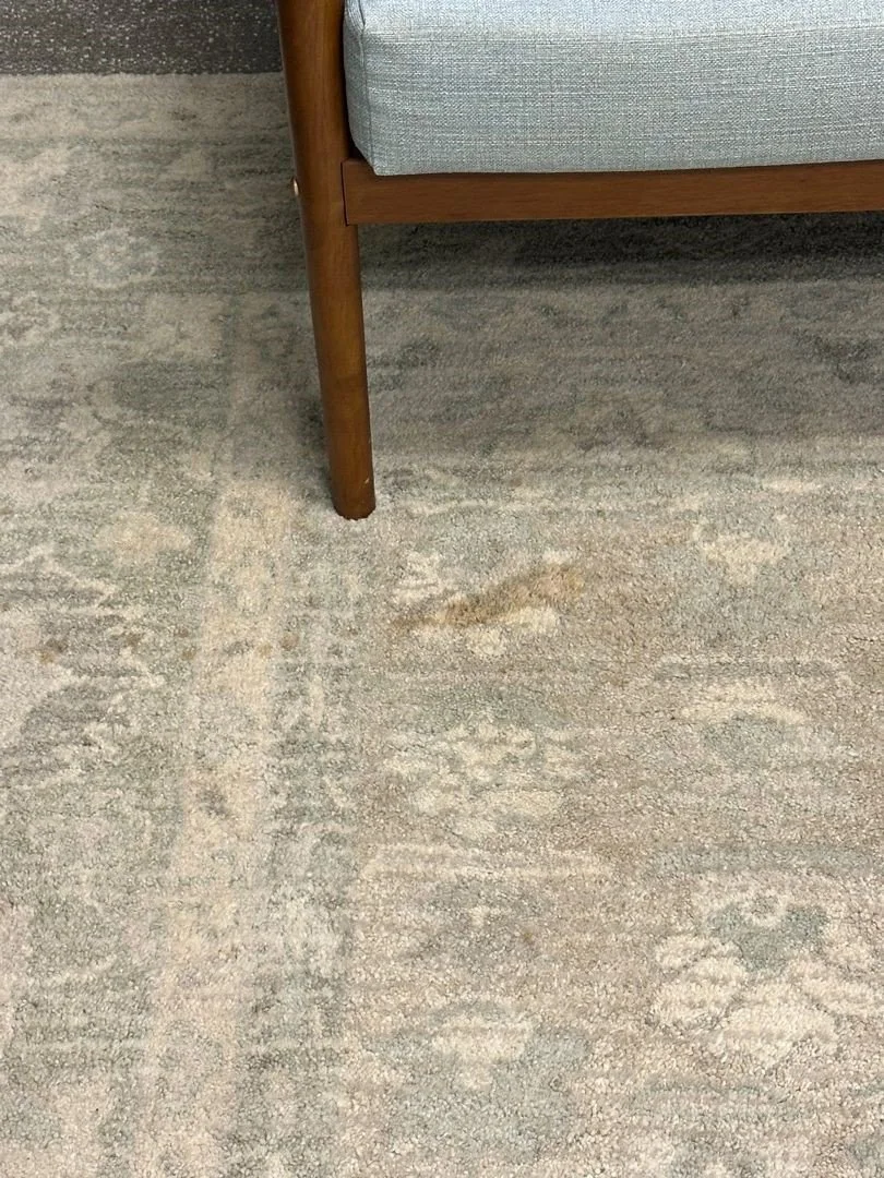 Stain on rug in office before ServiceMaster rug cleaning