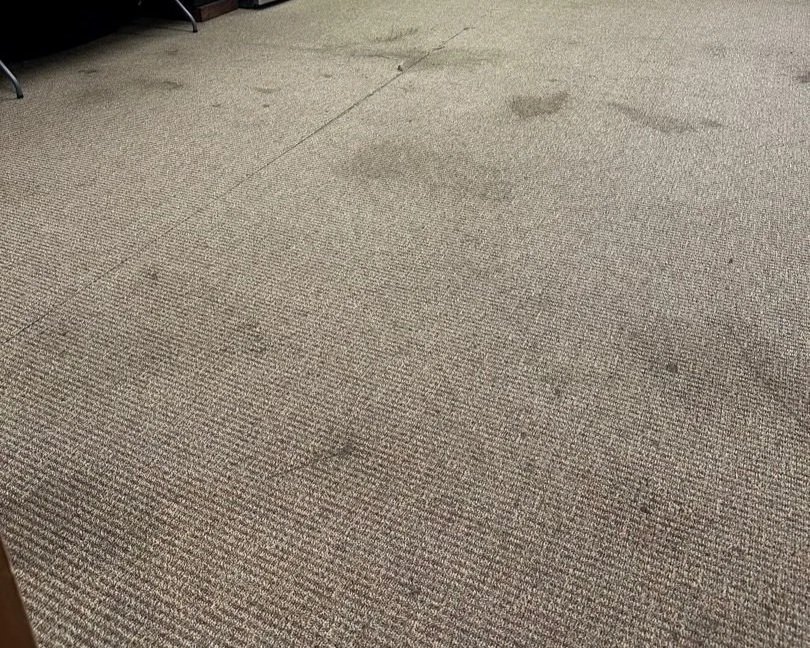 Stains on the breakroom floor before ServiceMaster carpet cleaning service was performed