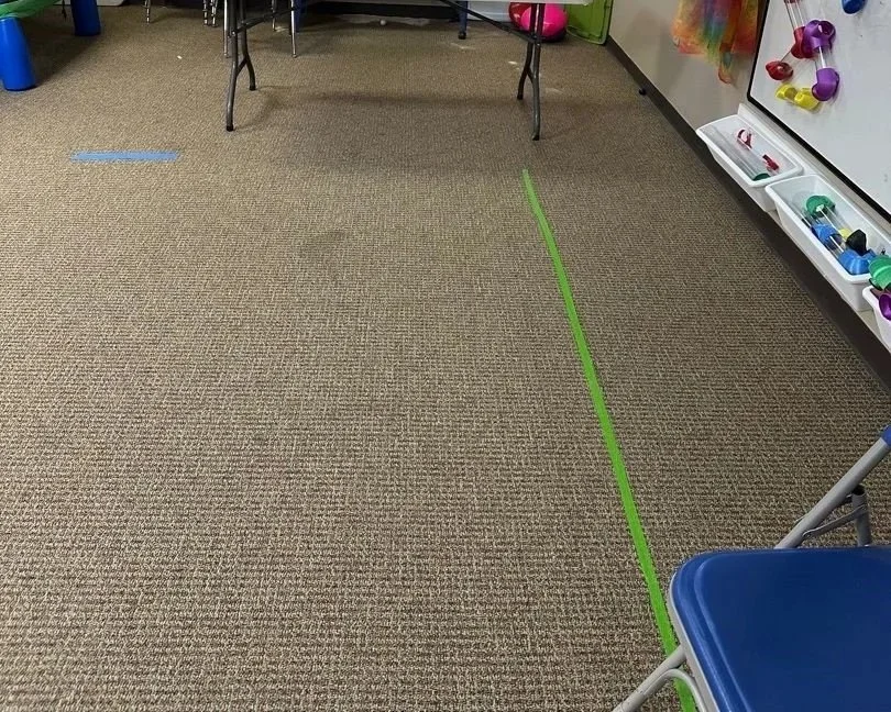 Stains and tape on carpet before ServiceMaster carpet cleaning performed