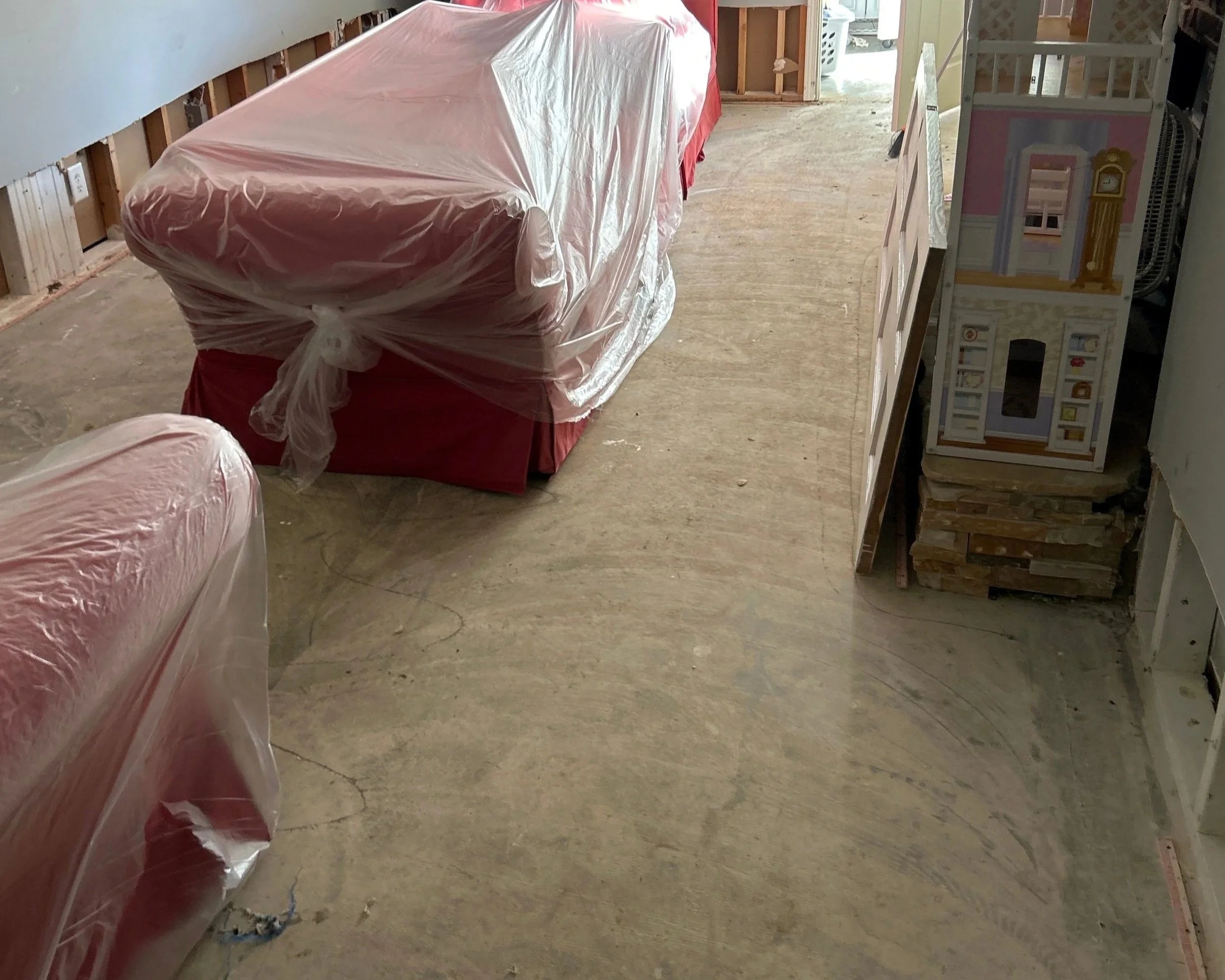 Living room is dried out and furniture is covered to protect during repairs