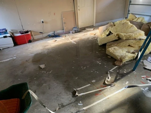 Insulation and water on the garage floor after a pipe burst during a freeze