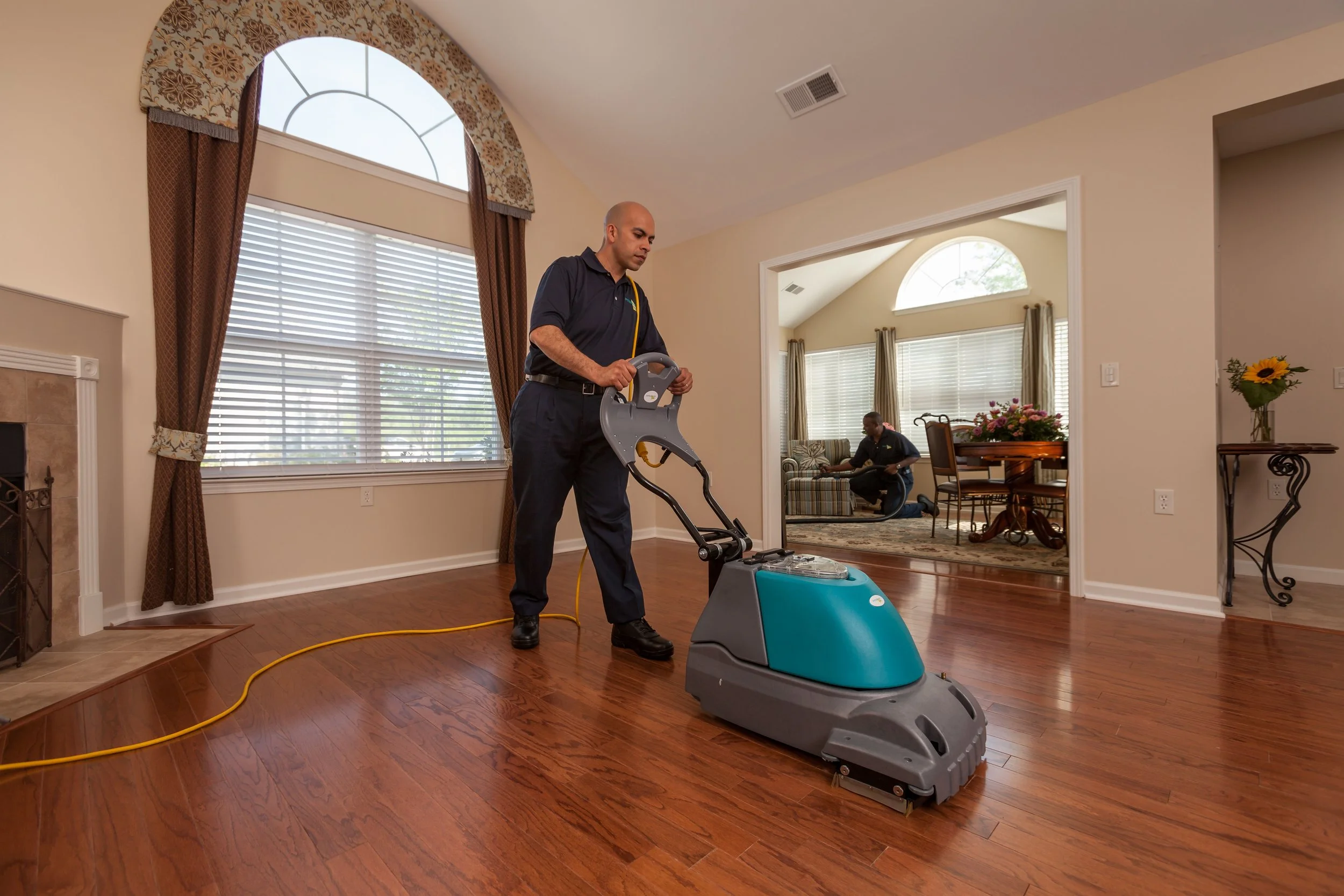 ServiceMaster technician cleaning a hardwood floor