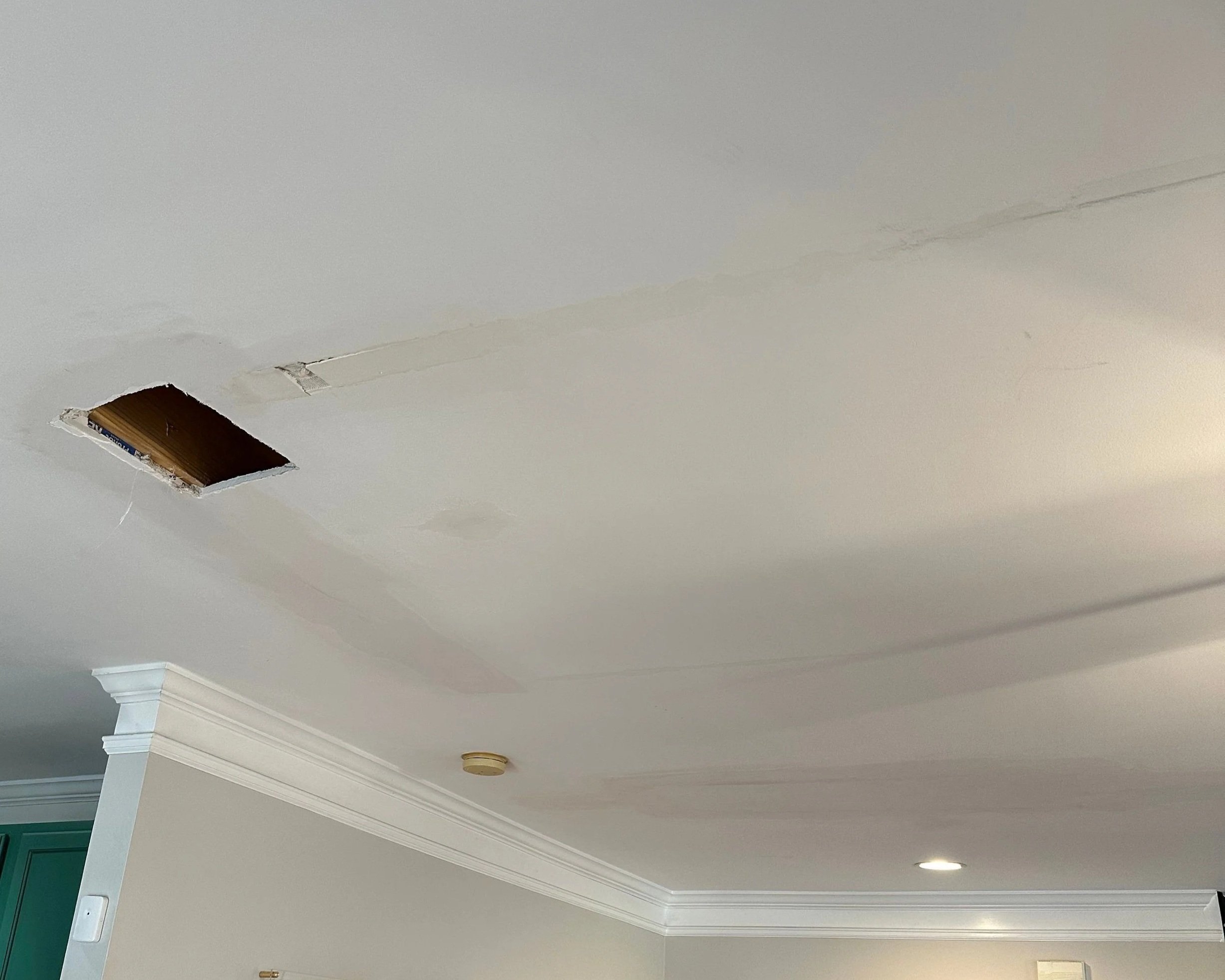 Water damage on living room ceiling from toilet supply line leak in bathroom above