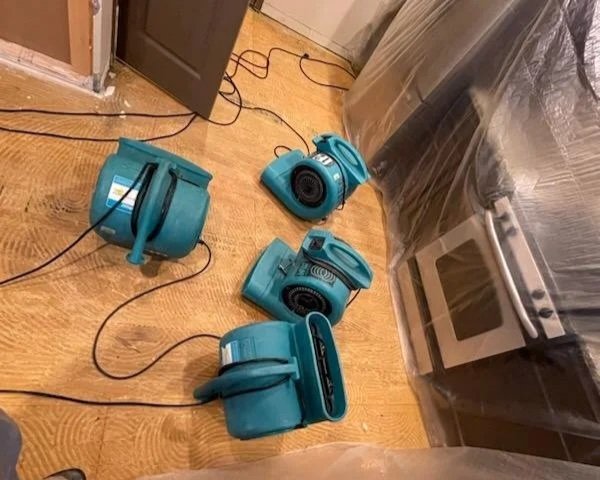 Air movers drying kitchen after damaged drywall and wood flooring were removed