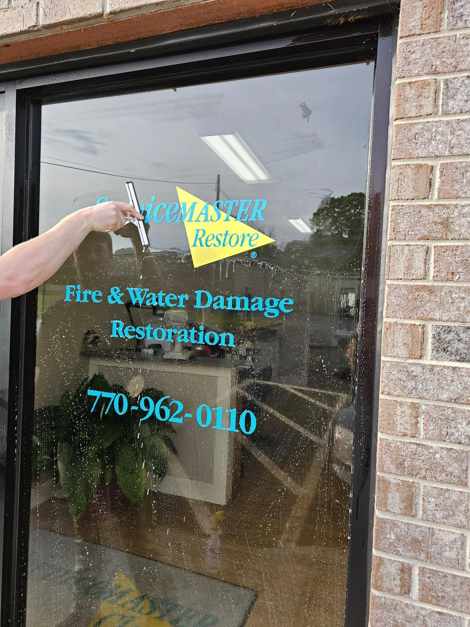 ServiceMaster technician cleaning office front window