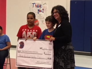 Students presenting their donation from their profits to their charity.