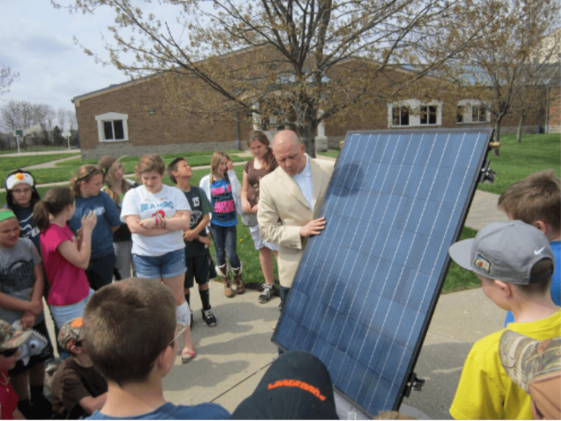 A parent, who served as our community partner, showing our students how his solar panels work.