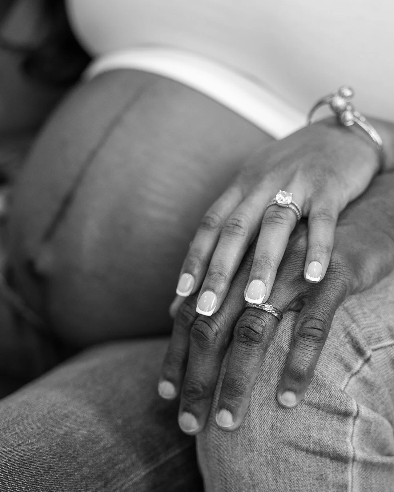 A pregnant woman rests her hand on her husband's