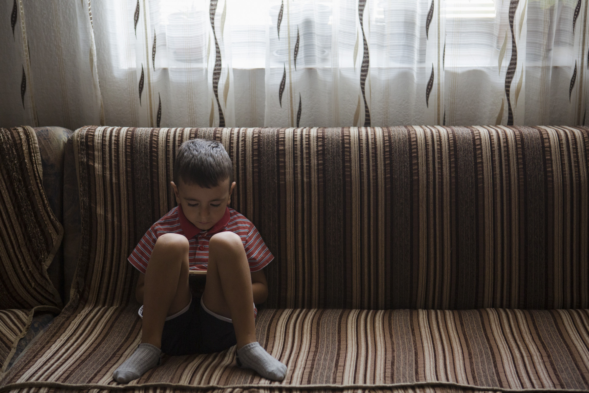  Leart Osmani, 4, plays on a phone at his home in Mitrovica, Kosovo. 