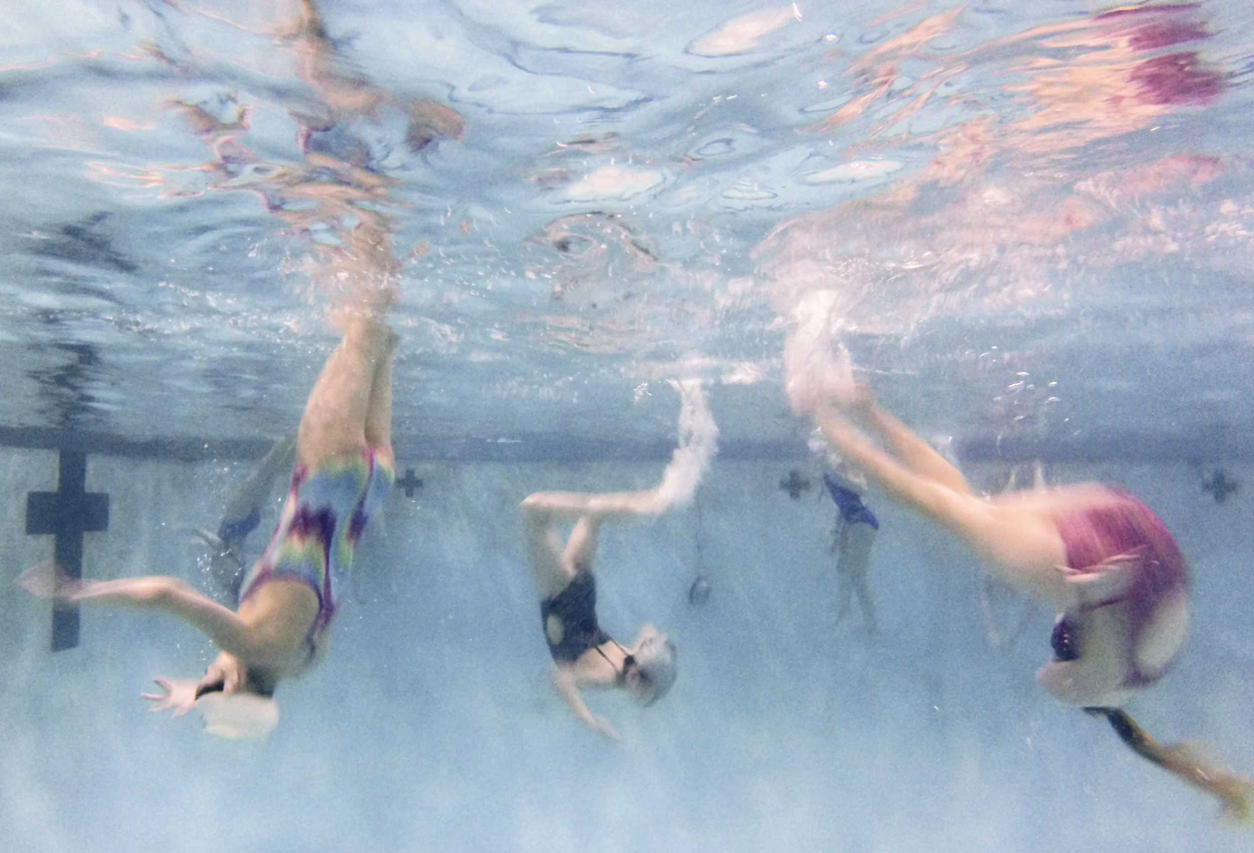 Members of a youth synchronized swimming team in Rochester New York practice together in the pool