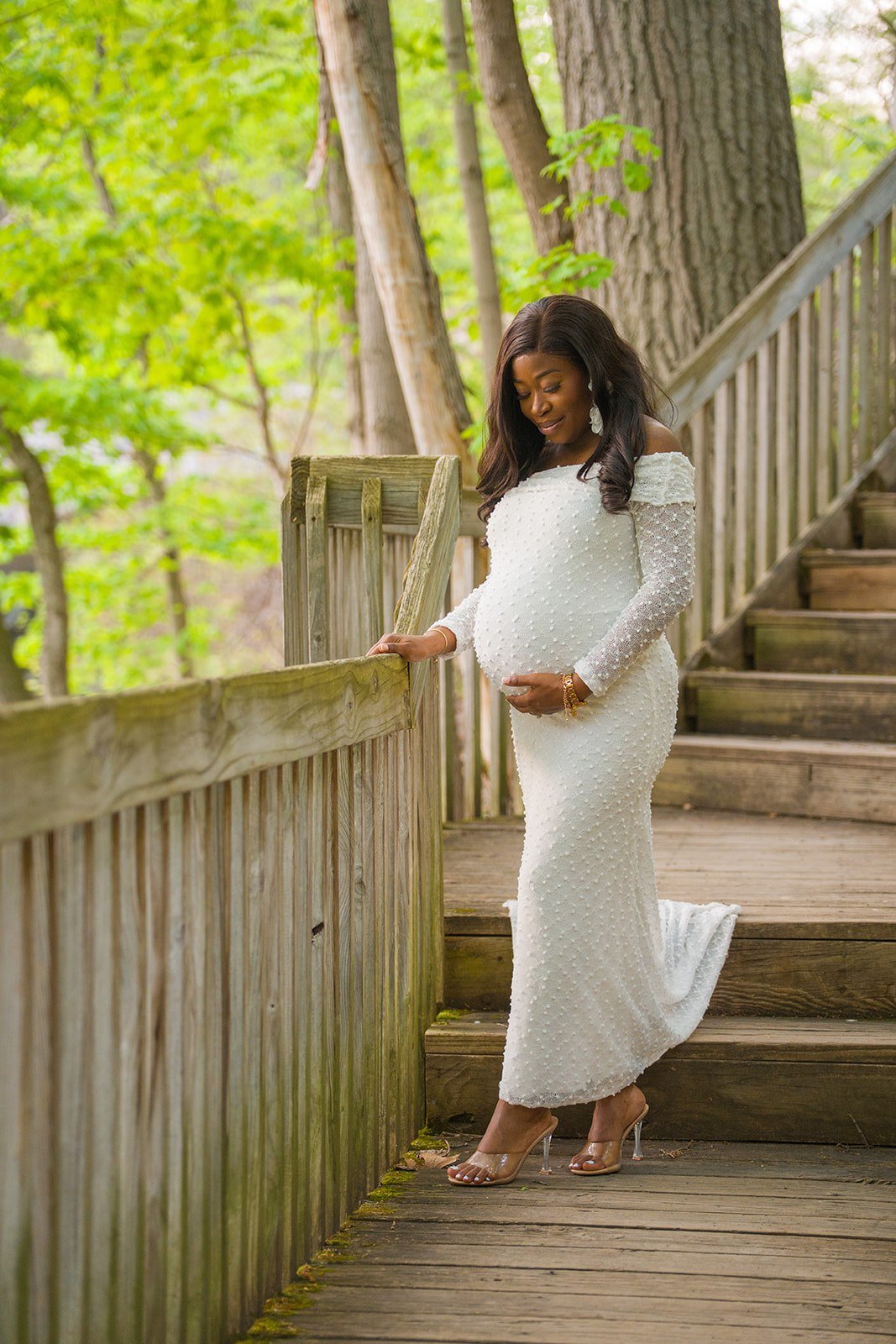 A pregnant woman holds her bump during a maternity session a Beebe Lake in Ithaca New York
