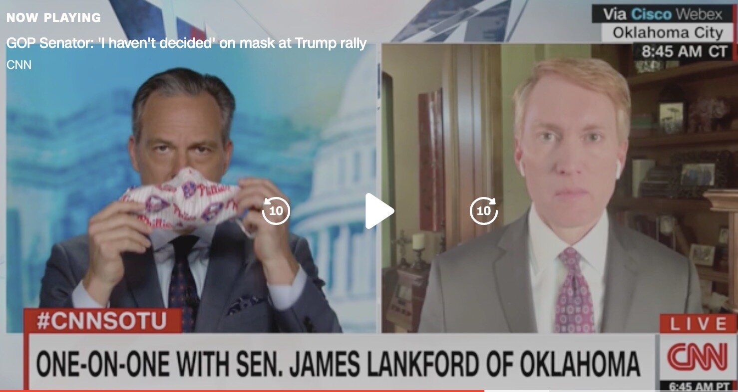 Jake Tapper (left) demonstrates what a mask looks like to the senator from OK.