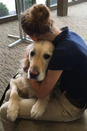 an Emmanuel – St. Michael student hugs a Comfort Dog