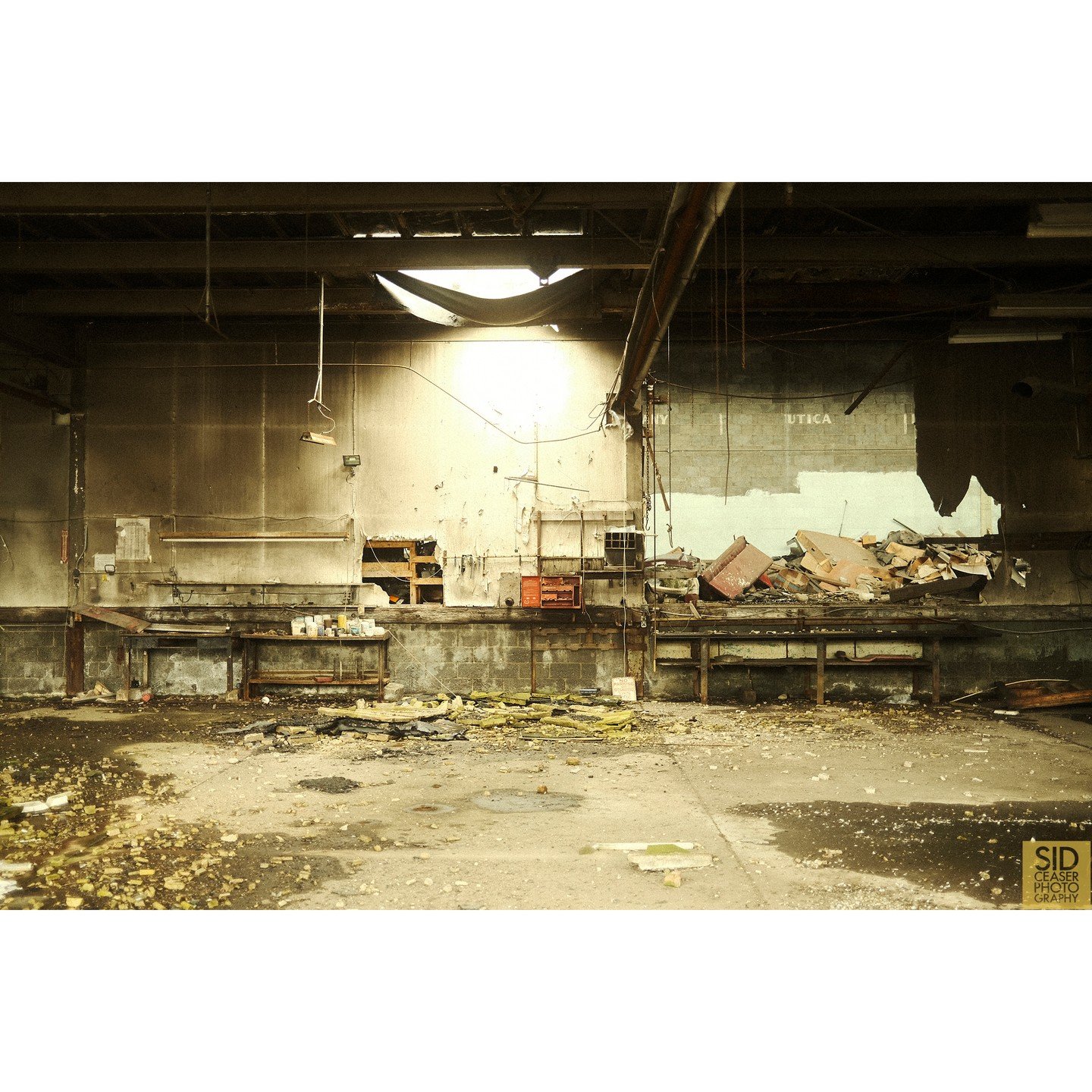 Peeking inside a broken window of Dudka's Garage in Amsterdam, New York. The hole in the ceiling was letting light pour into the abandoned shop, and it was just a gorgeously lit area. I Love the tones on the back wall; going from grey to an almost of