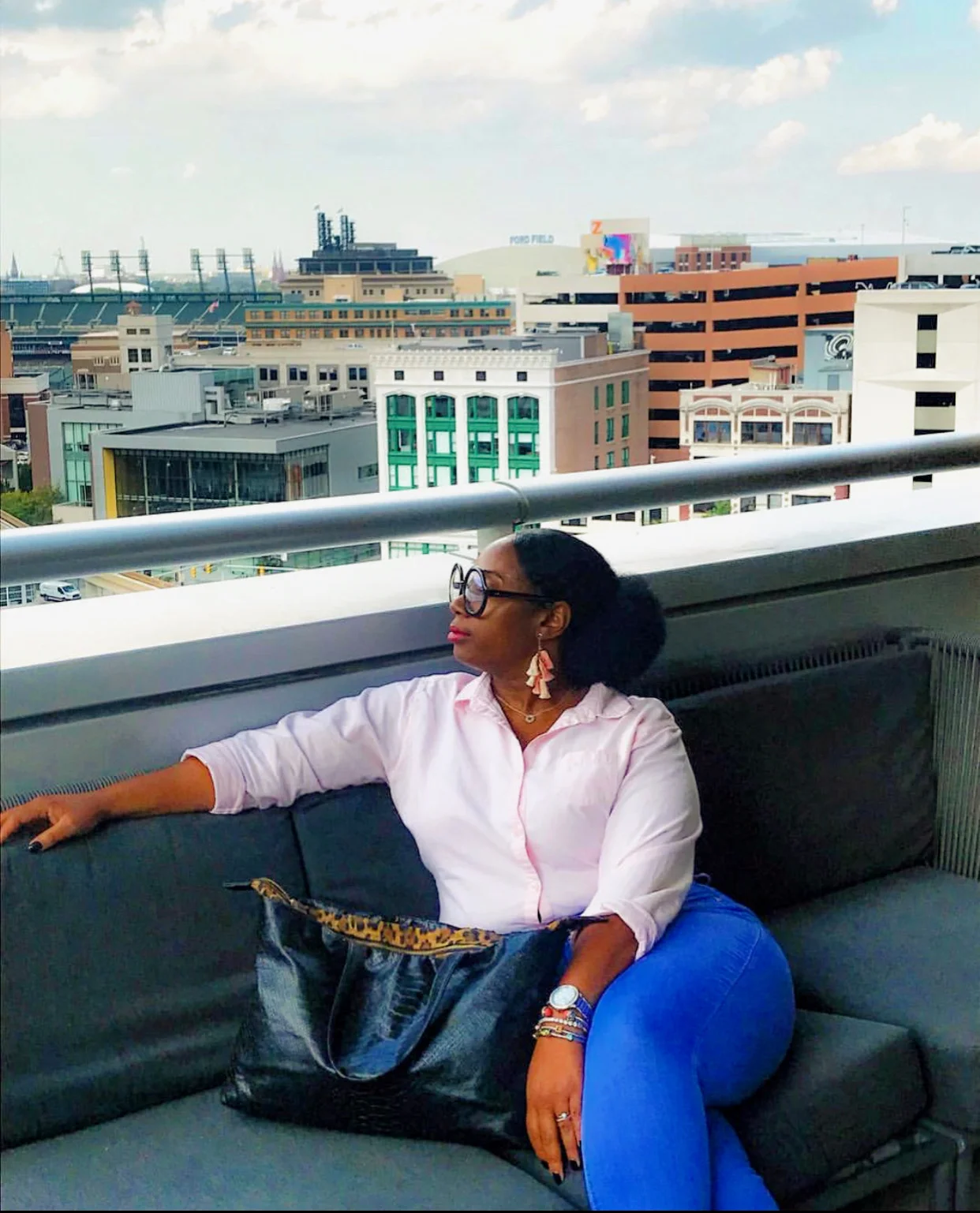 Amira Estell, founder of Mira Estell, wearing her own earring and handbag designs.