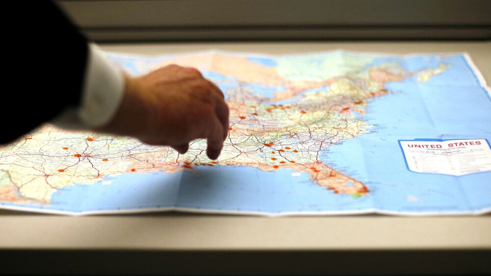 LAPD Detective Rick Jackson examines a map in March 2013 dotted with locations