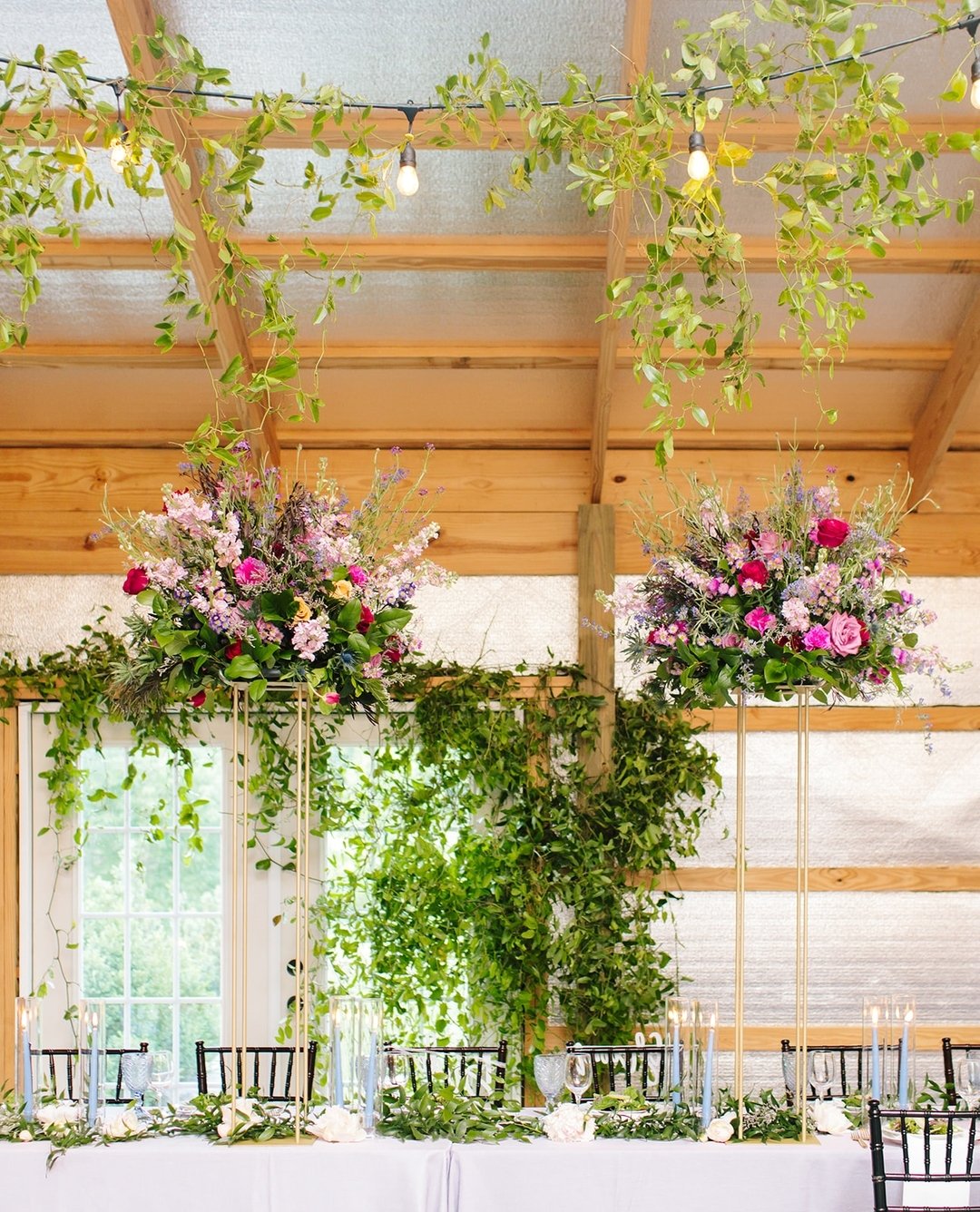 So, this is a barn. With a kind of unfinished wall back there. 
But, it's a pretty vineyard, yummy wine and outdoor views...
So, we brought the flowers up front and over the top and added greenery galore.
If your space needs a dot of creativity to el