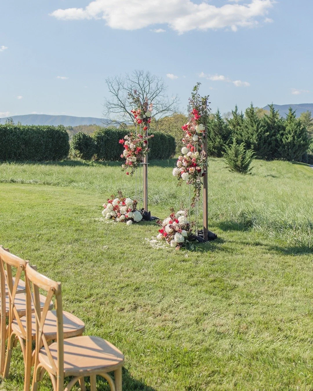 Let’s talk ceremony florals! If you’re looking to make a big floral statement, bold colors and added height are the way to go. Sarah and Jim wanted something a little different — no full arbor here — so we created these floral