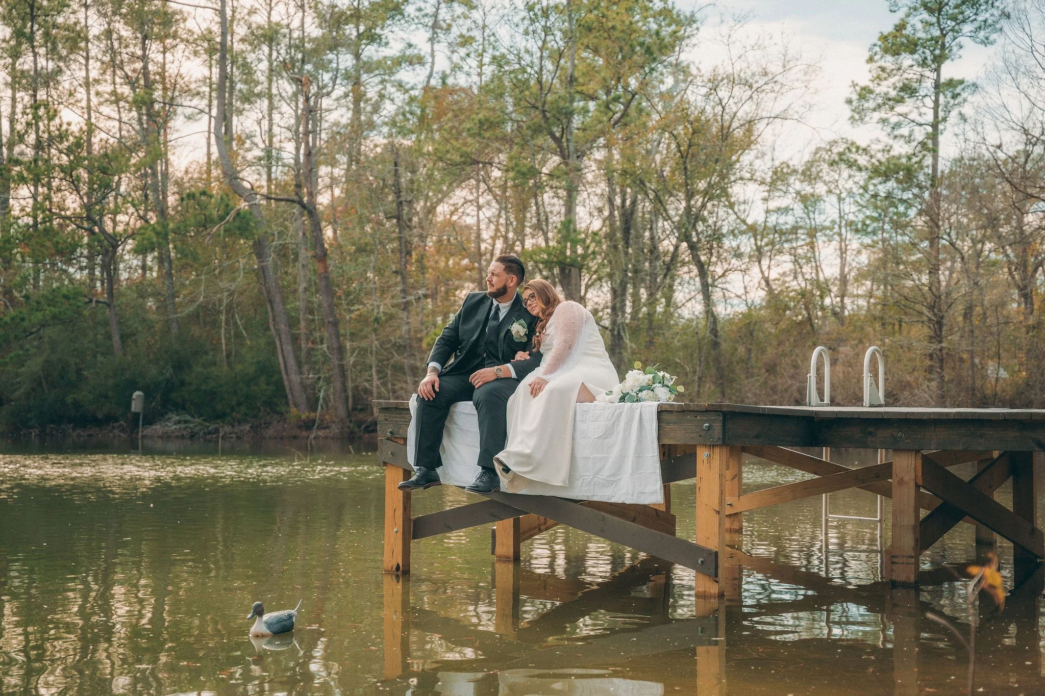 married couple sit on wooded deck looking out