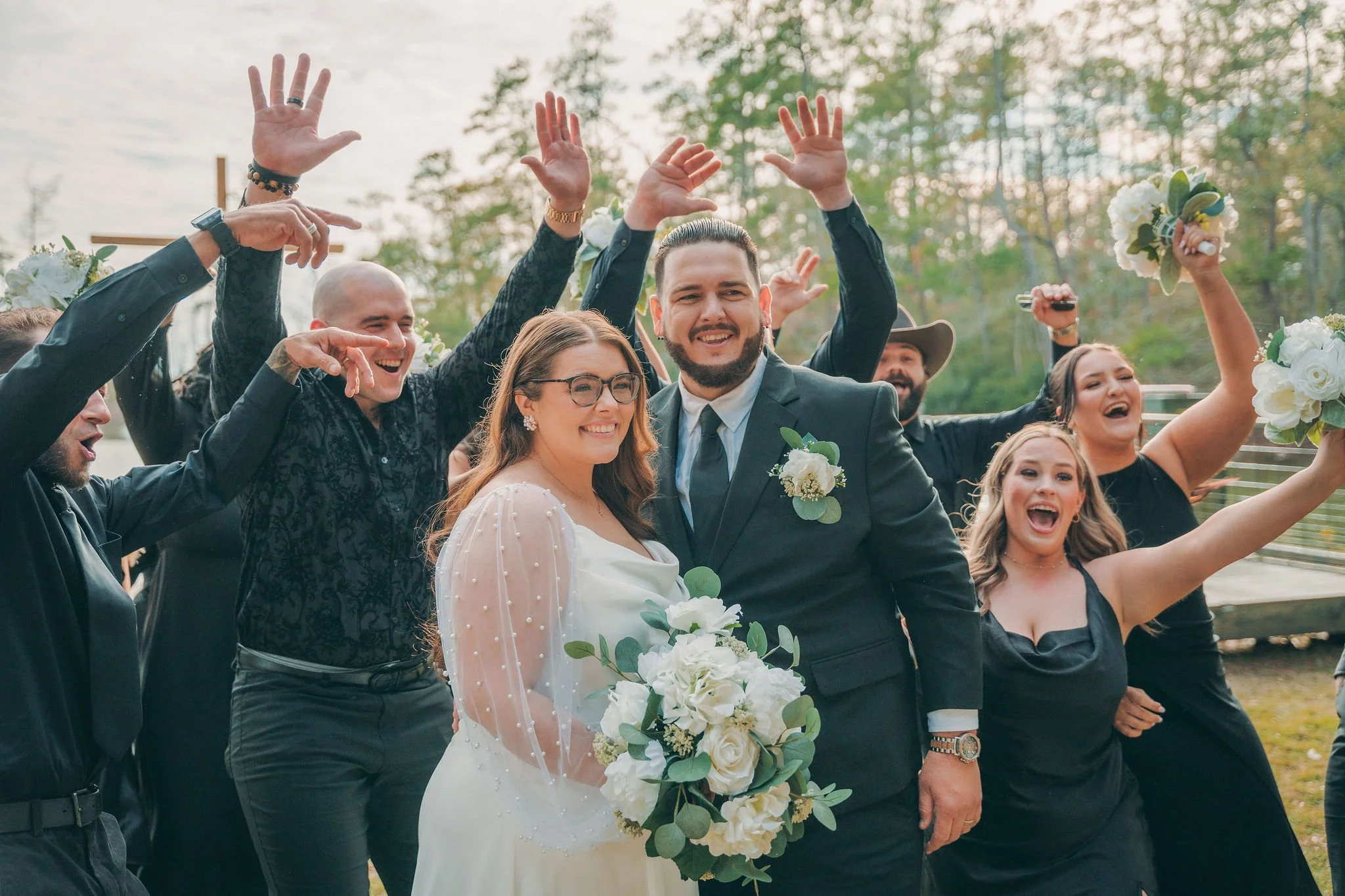bridal party celebrating behind bride and groom after ceremony