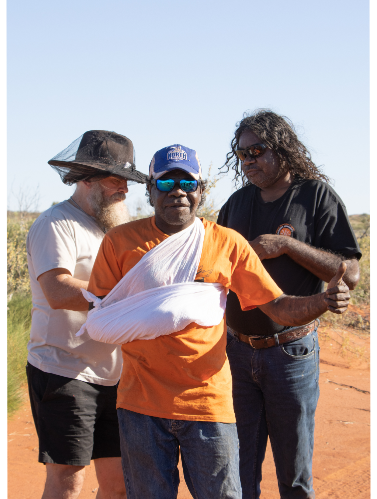 Neil demonstrates using sling and swathe with Punmu Rangers Neil and CJ.png