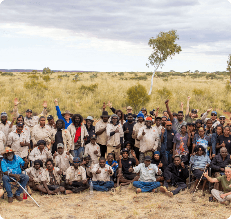 Large group of KJ Martu rangers together on Country, reflecting the community impact of KJ's Martu-led cultural and land management programs
