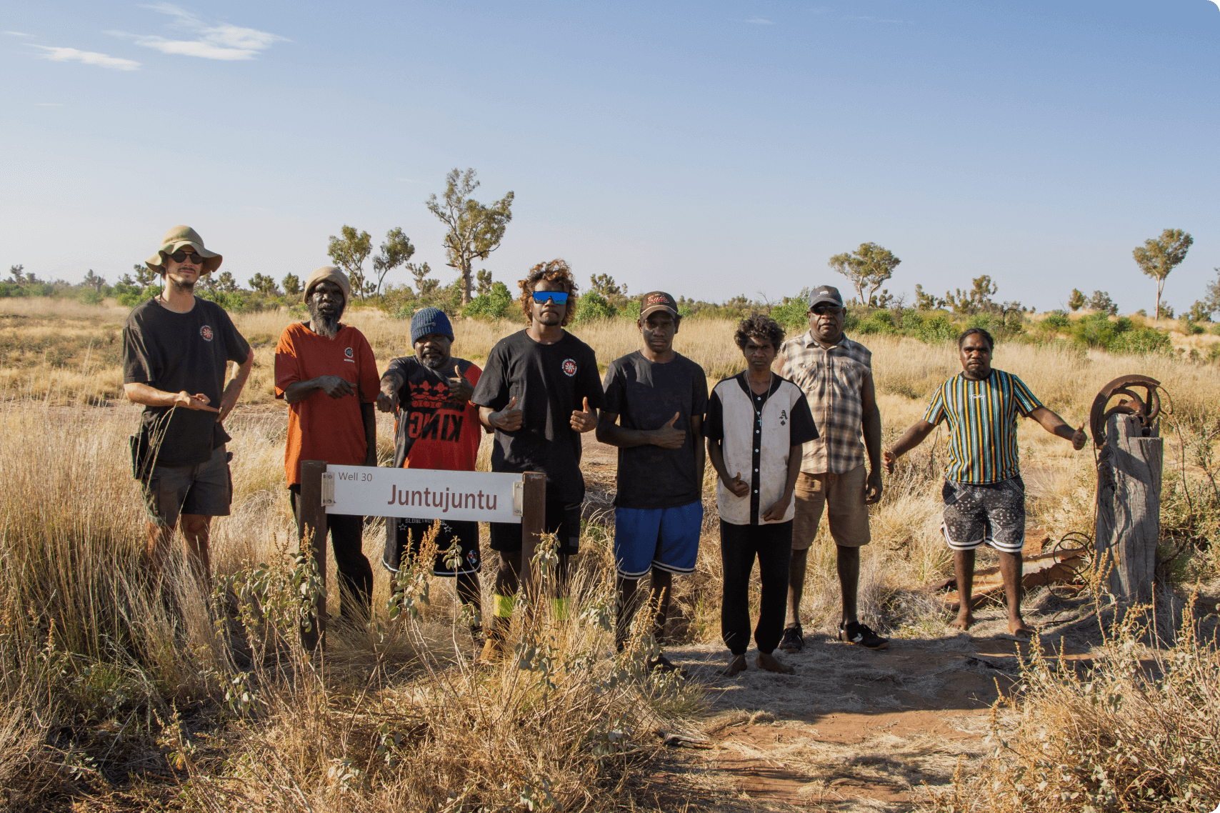 KJ Martu Rangers standing together on Country during community-led work, reflecting the outcomes guiding KJ’s impact and partnership with Martu communities.