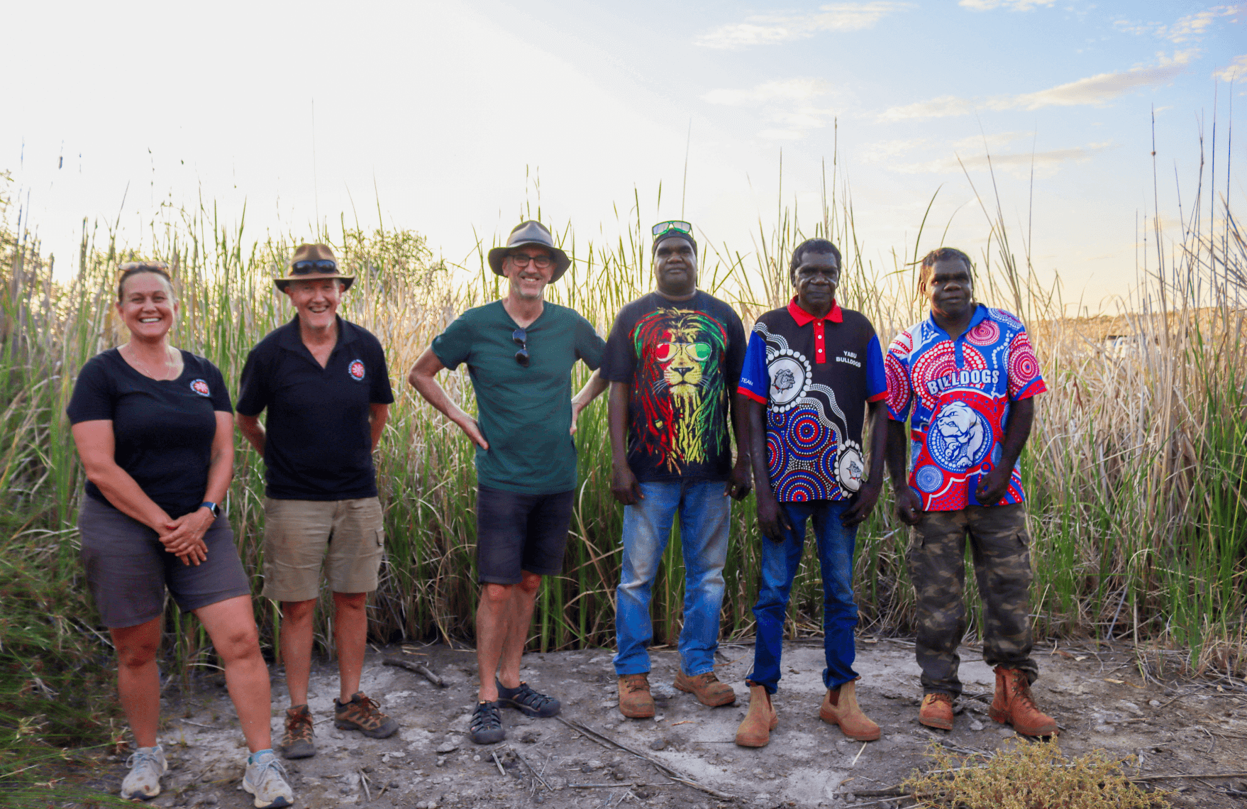 Kanyirninpa Jukurrpa board members standing together on Country, representing Martu and non-Martu leadership working in partnership to support strong governance and community-led decision making.
