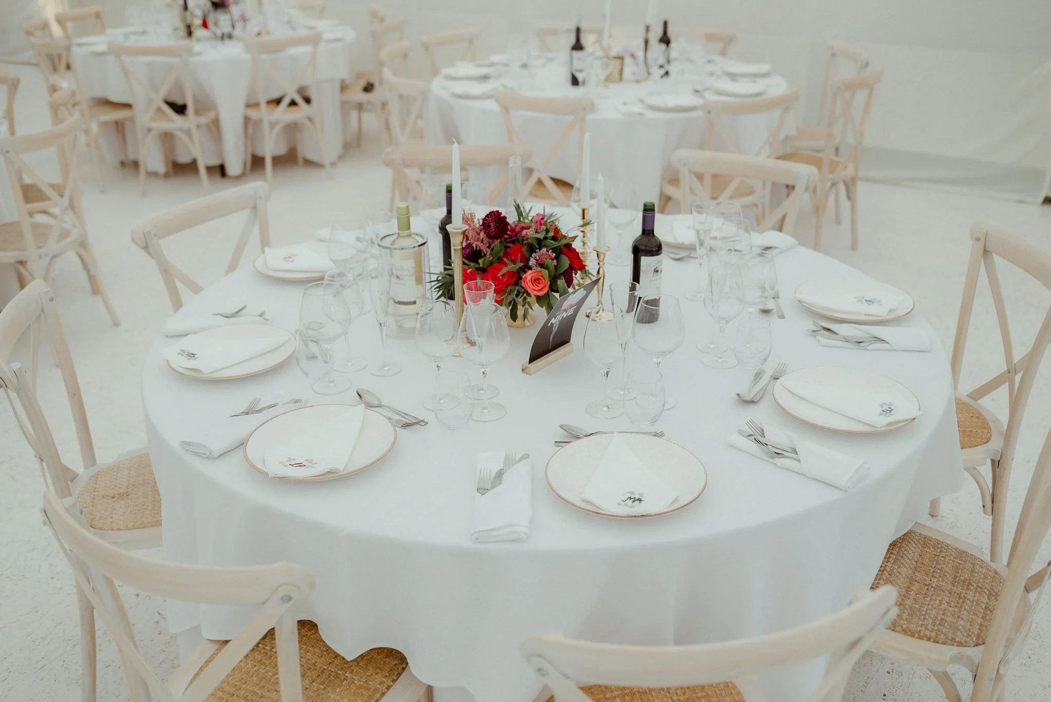 Gold urn wedding table centrepiece with flowers in burgundy, deep red and pinks