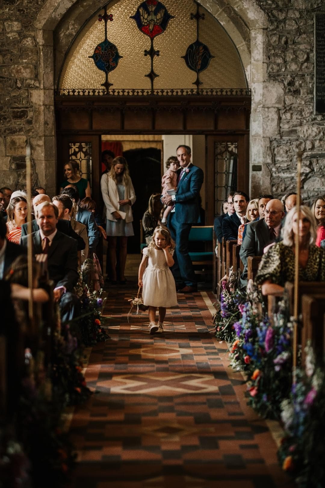 Flower girl walking down the aisle lined with flowers.jpg