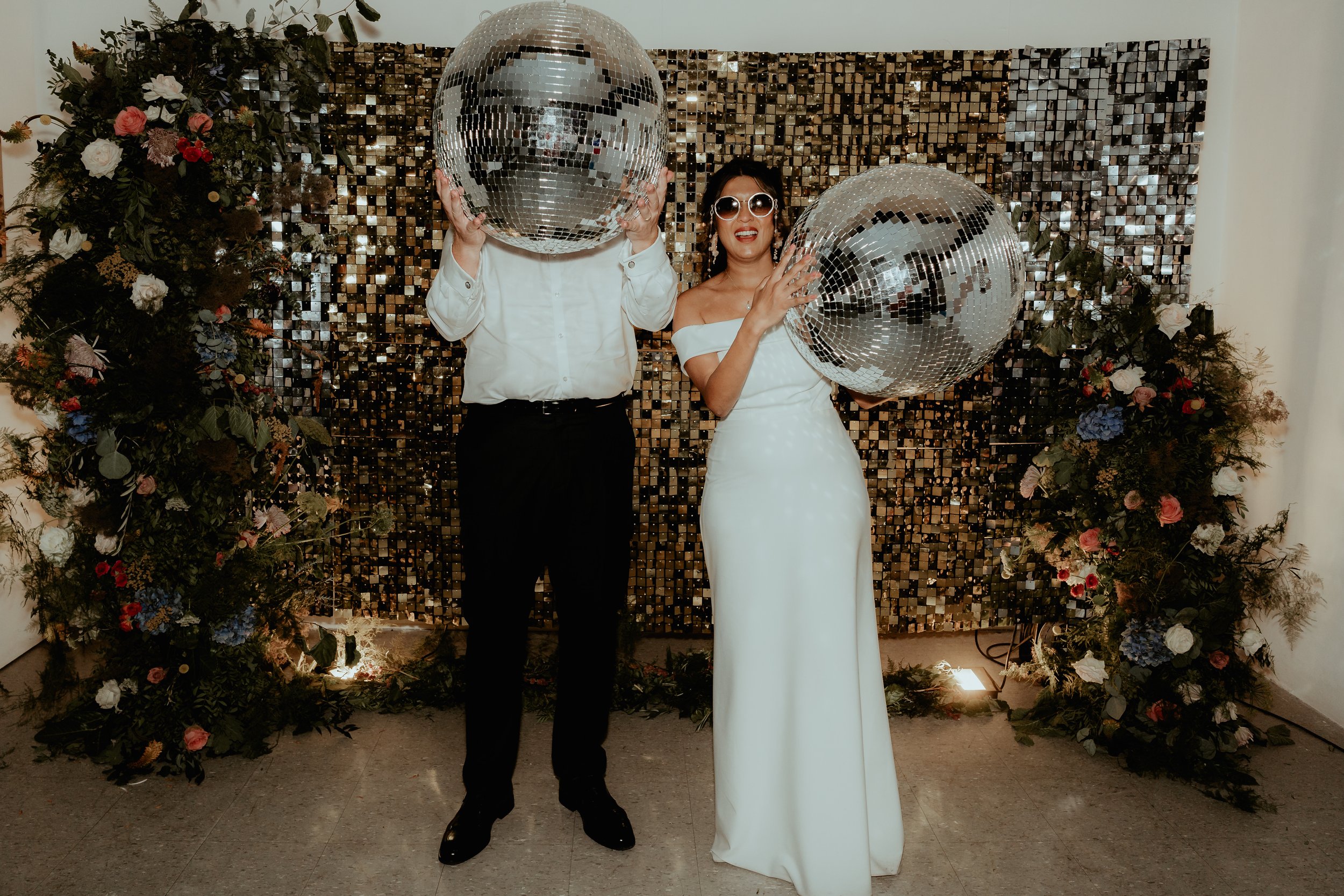 Bride and groom with floral pillars and mirror balls.jpg