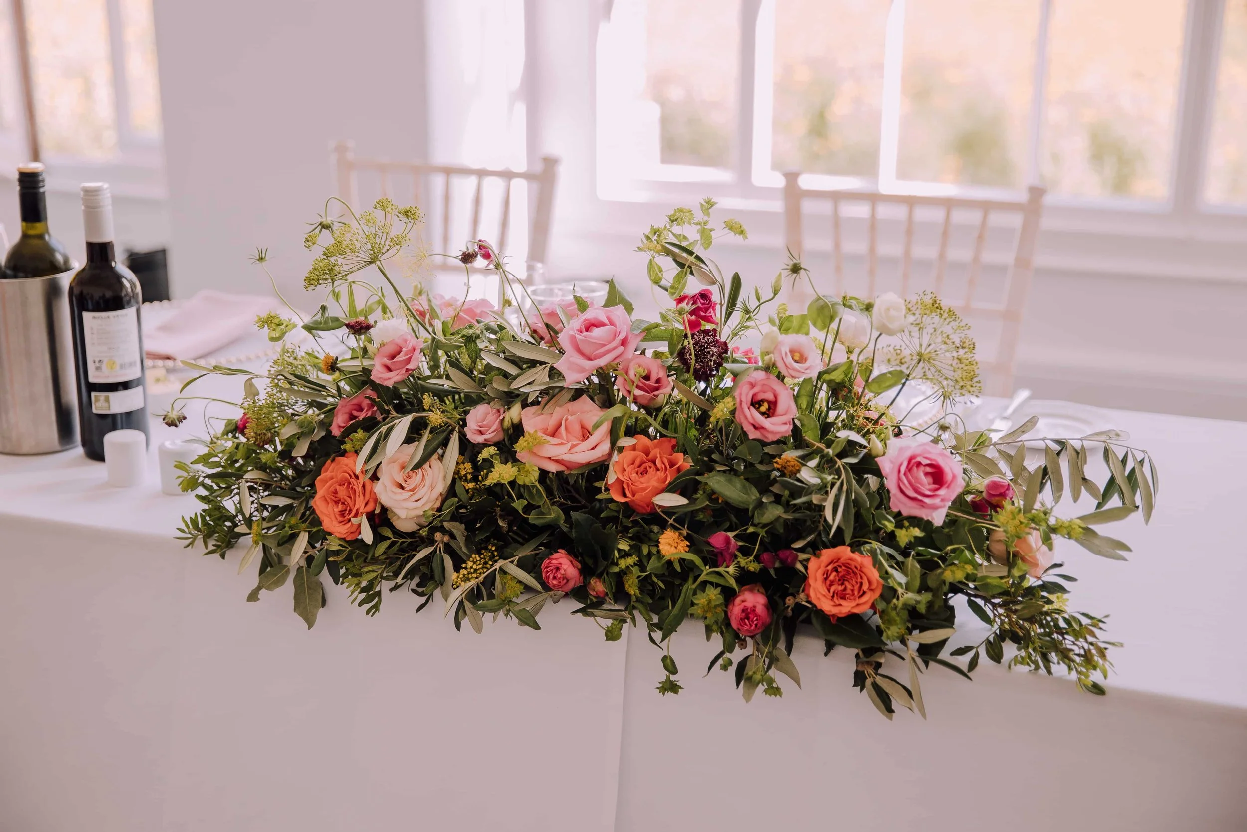 Top table long and low wedding flower display.jpg
