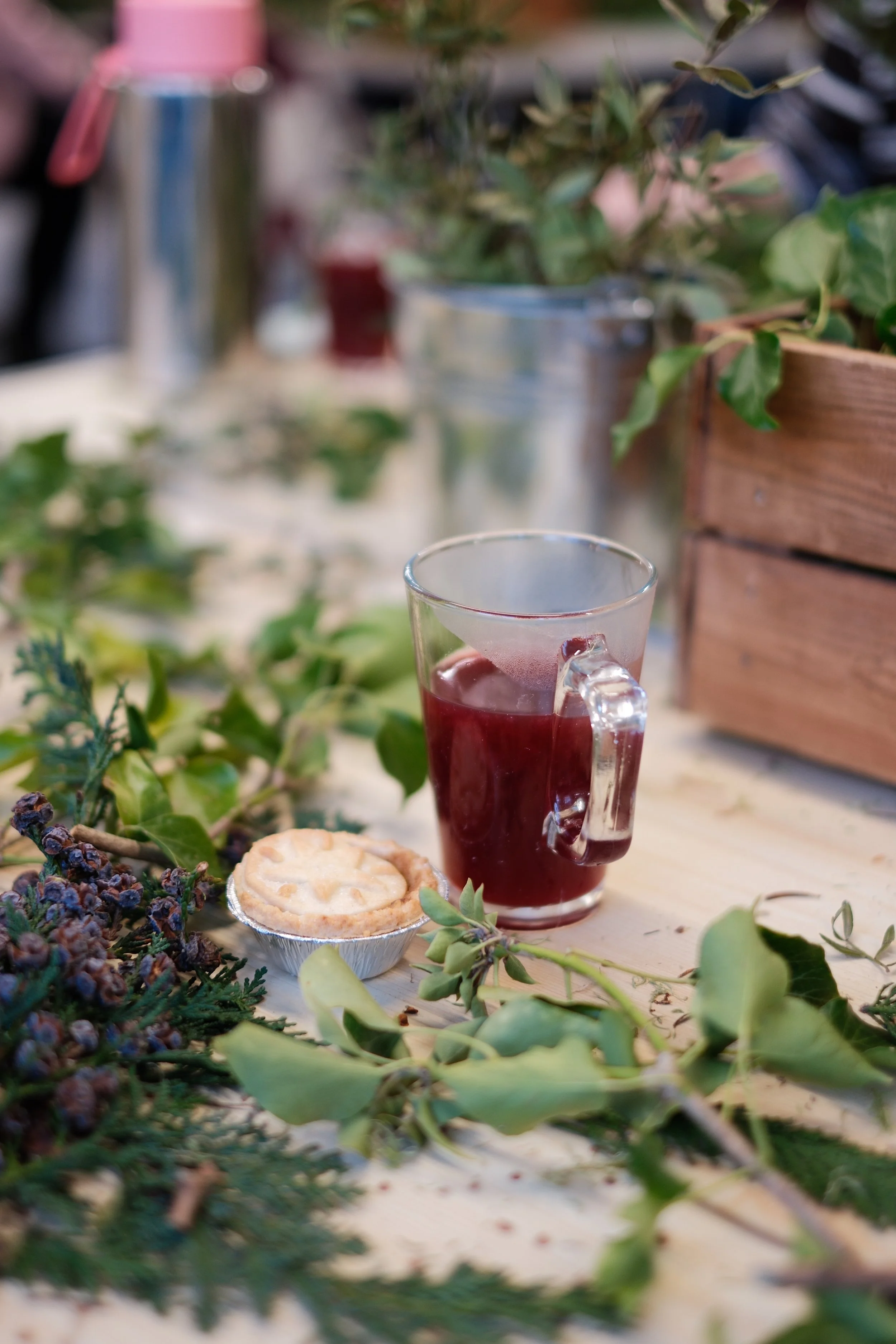 A picture of hot mulled wine on a table of Christmas foliage at the wreath class in Cardiff