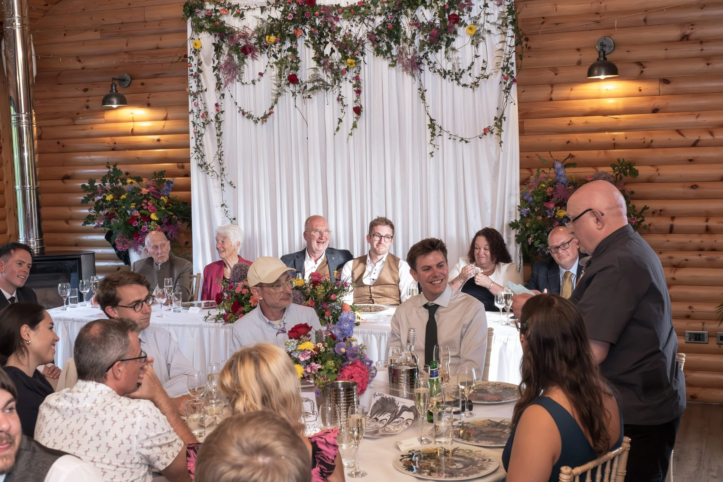Wedding speeches with colourful reception flowers for same sex wedding at Rhodri's by the Lake Canada Lodge, Cardiff