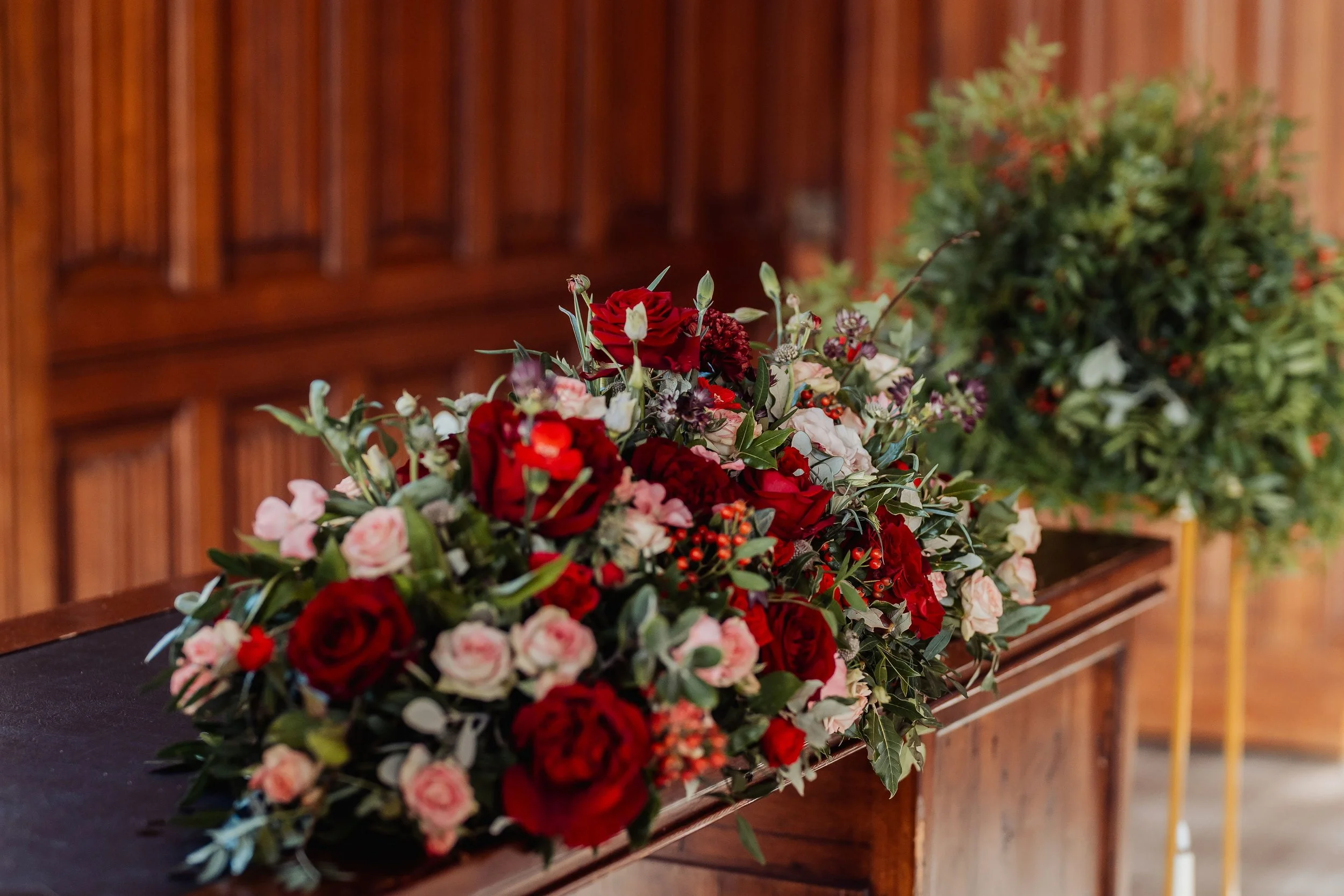 Closer details of the low registry arrangement at Hensol Castle, the display is full of burgundy and soft pink roses, red dianthus, rose hips and luscious foliage