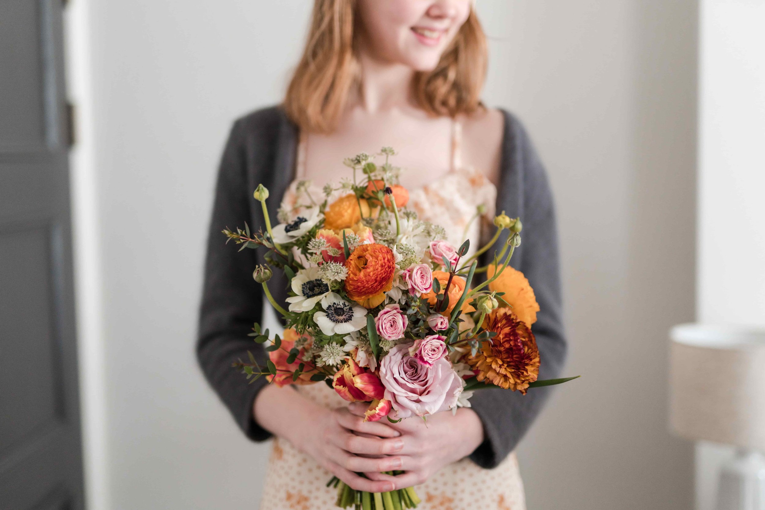Bridesmaid with spring orange and peach  flower bouquet