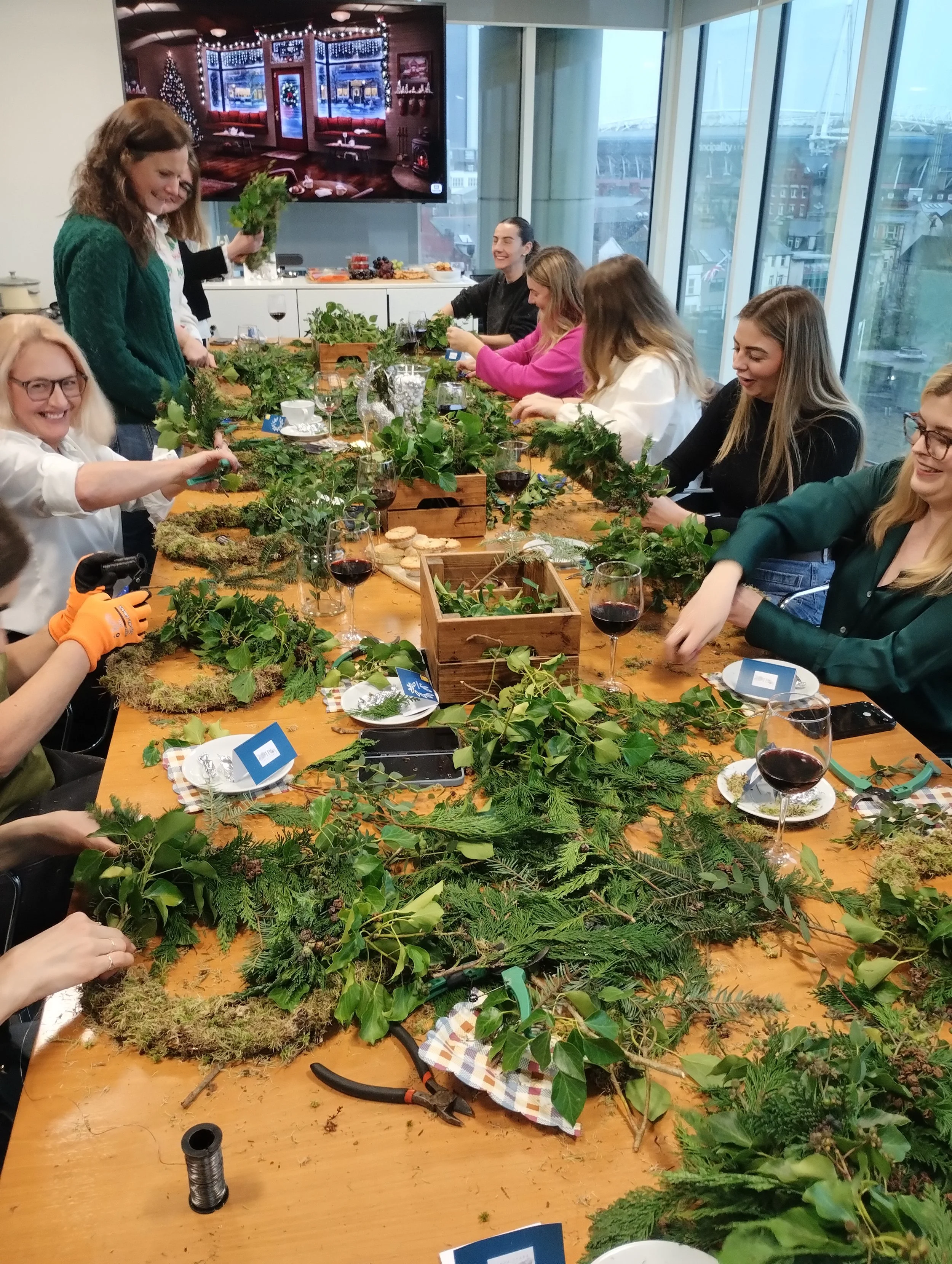 A group of colleagues working together on their wreaths at a workshop