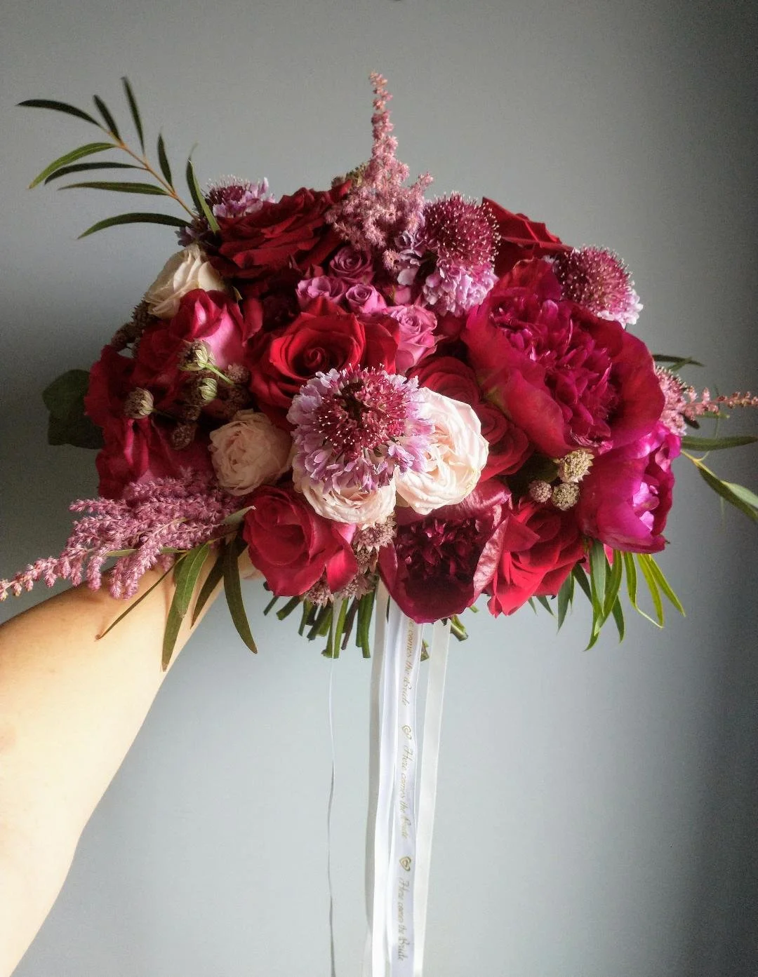 The bridal bouquet in rich tones of burgundy, red and pink